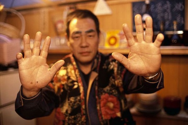 September 1993, Japan --- A member of the Yakuza Mafia displays his hands which are missing most of the pinkies. Fingers are cutoff as a sign of loyalty.