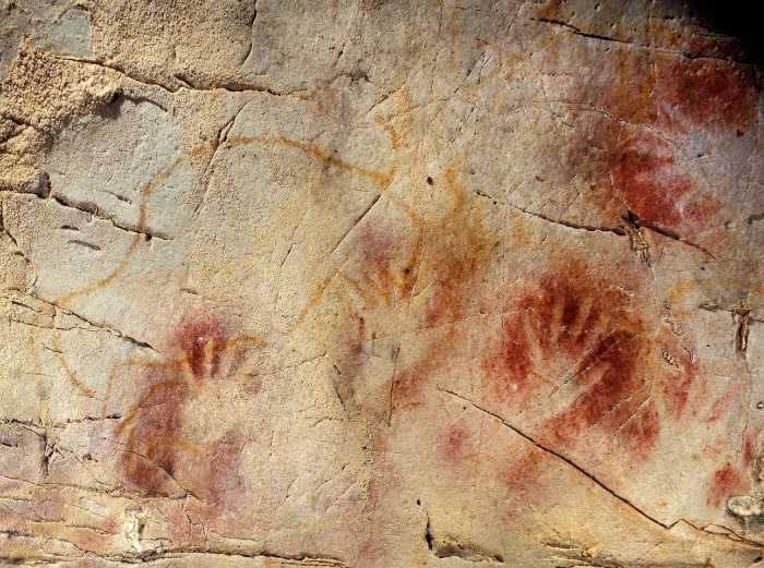 Handprints on the wall of El Castillo Cave in northern Spain have been radiocarbon dated by scientists to be at least 37,300 years old. Credit: Pedro Saura, Wikipedia.