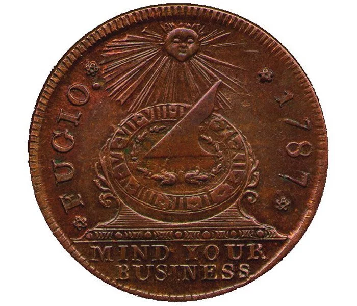 The first official coin of the United States was the fugio cent. Benjamin Franklin developed the motto and its visual representation.