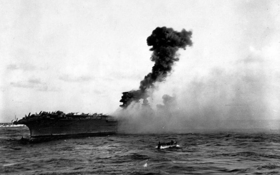 On the afternoon of May 8, 1942, when the USS Lexington (CV-2) was being abandoned, an explosion occurred amidships. Perhaps this was the blast heard at 5:27 pm, followed by the massive blast heard thereafter when torpedo warheads stored on the hangar deck went off. You may see a whaleboat in motion in the foreground. (Image: Naval History and Heritage Command)