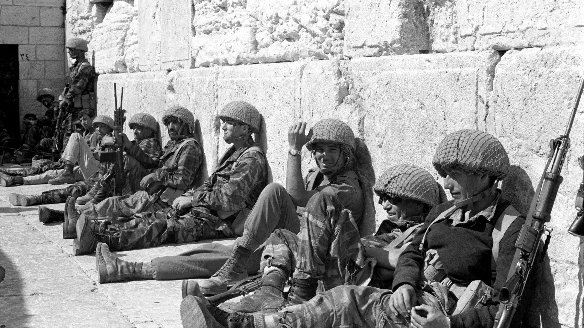 Israeli soldiers sit in front of the Western Wall in Jerusalem's Old City