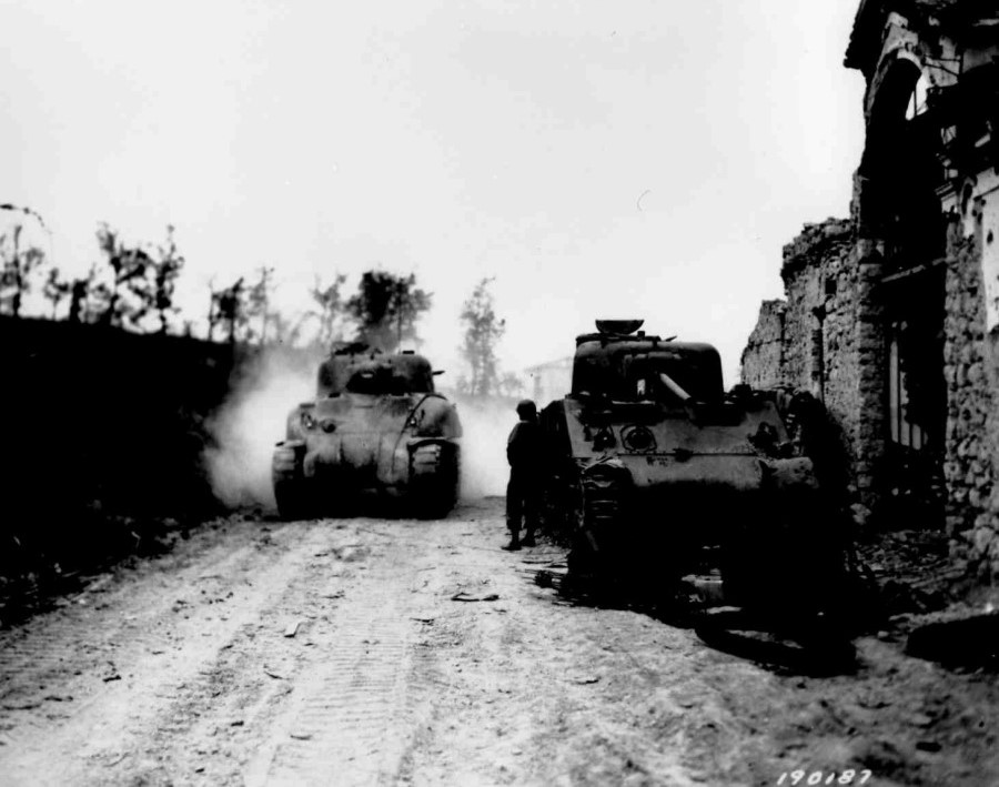 On May 12th, 1944, in Minturno, Italy. At the outset of Operation Diadem, an M4 tank from the 756th Tank Battalion drives by a knocked out British M4.