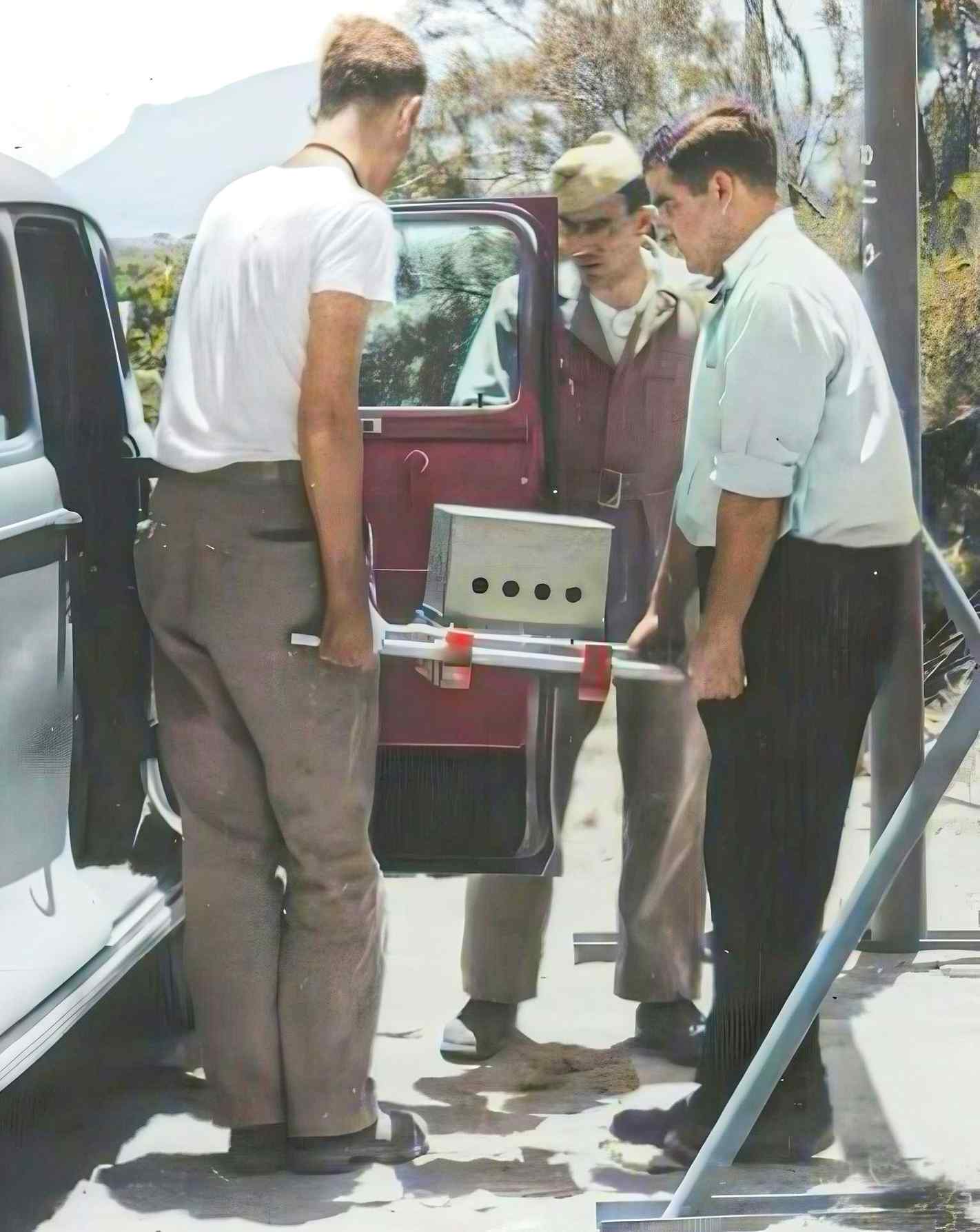 Herbert Lehr (left) and Harry Daghlian, Jr. (right), loading the assembled tamper plug containing the plutonium pit and initiator during the Manhattan Project. (Colorized)