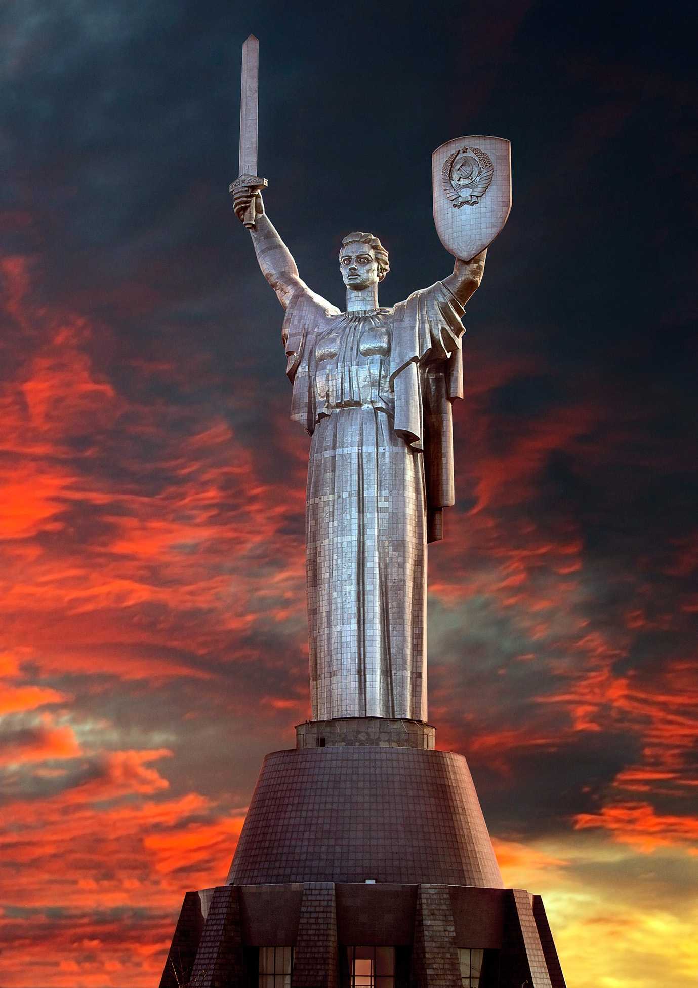 Motherland Monument (the previous name of the Mother Ukraine) in the crimson rays of sunset with the old shield design.