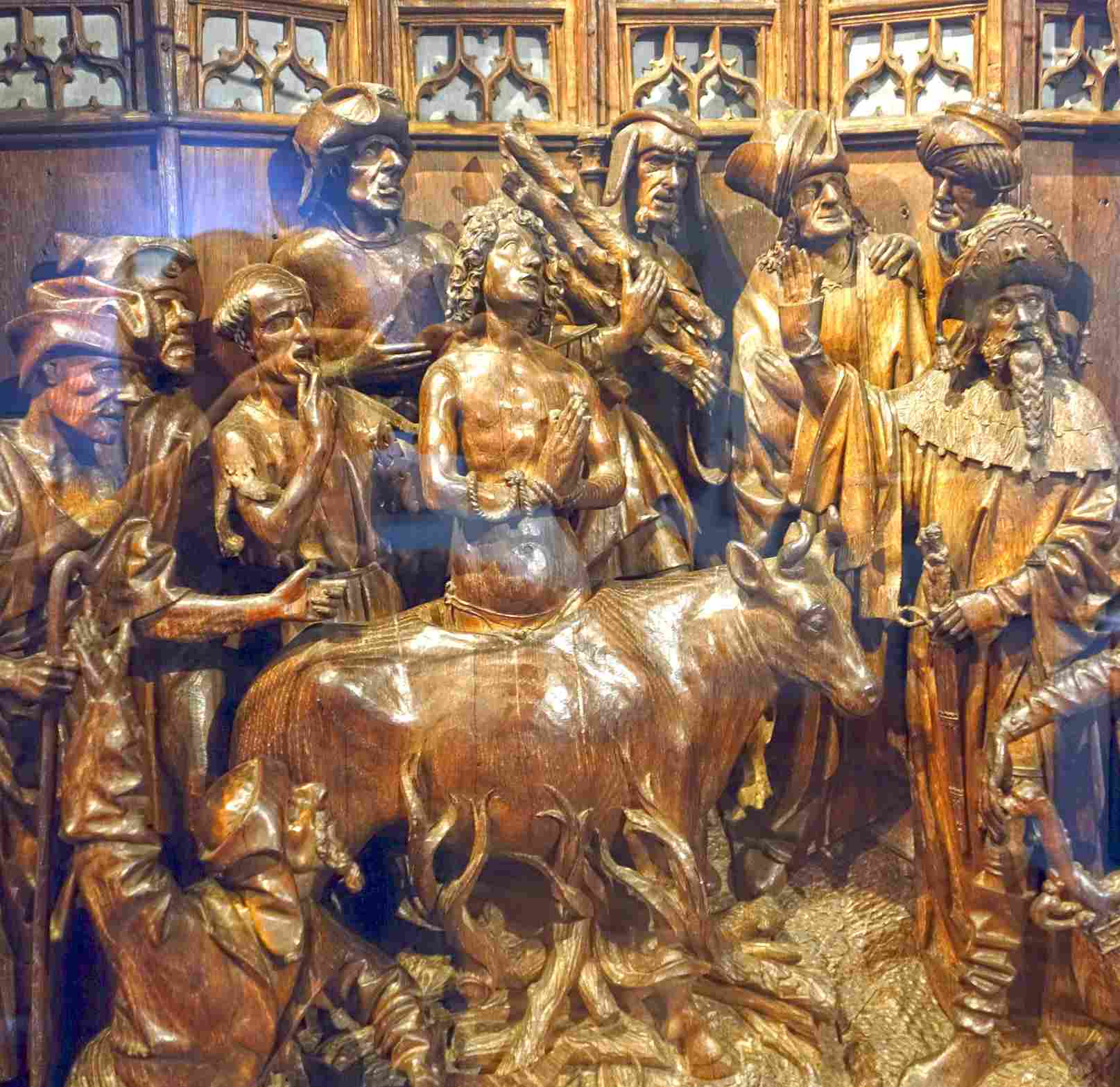 The altarpiece of Saint George (1493). The martyrdom of Saint George. The saint is dipped in a bull-shaped cauldron filled with boiling lead. To his right is emperor Diocletian, with braided beard.