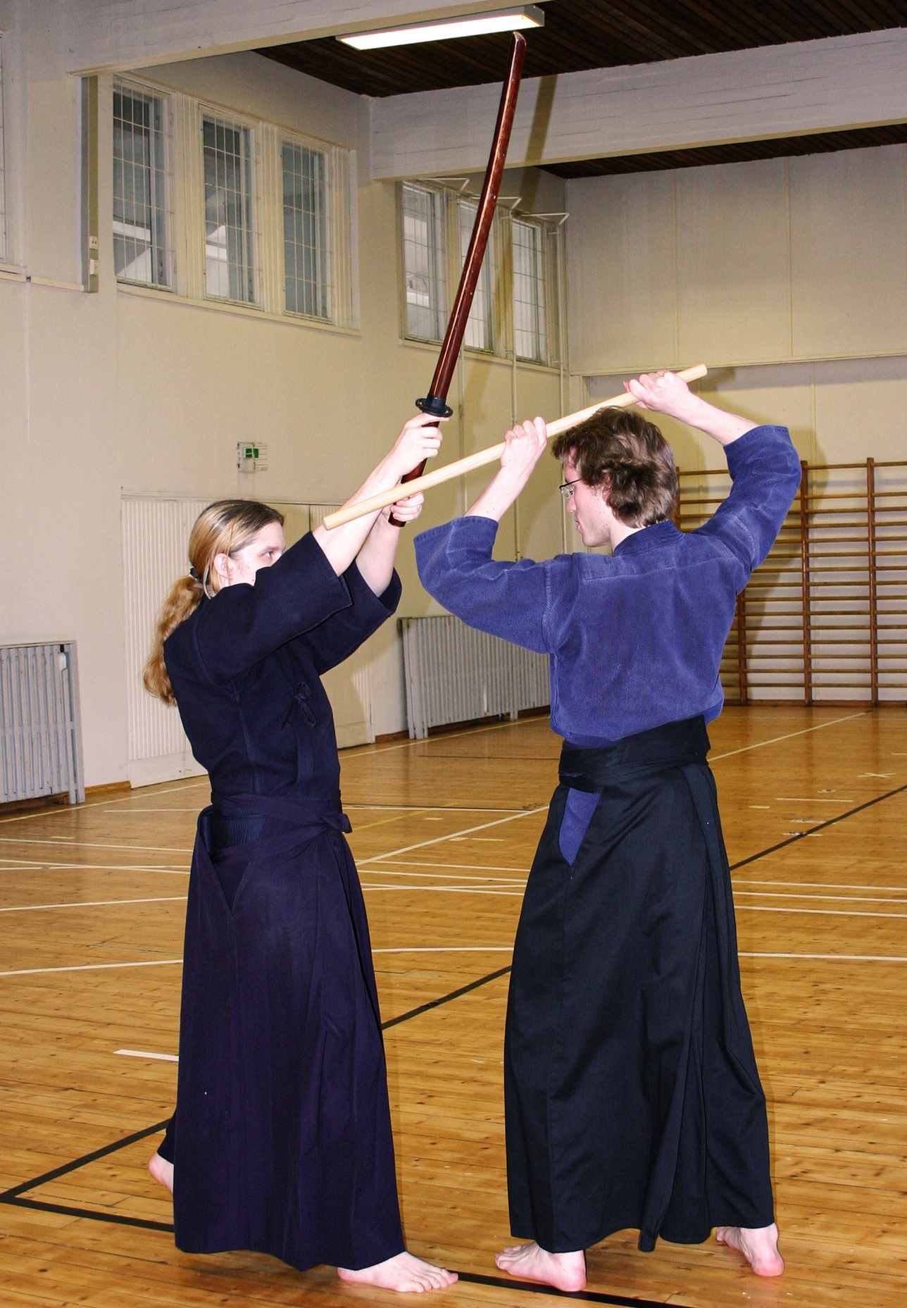 A jodo practitioner stops the strike of a bokken by intercepting the attacker's wrists with the tip of his jo staff.