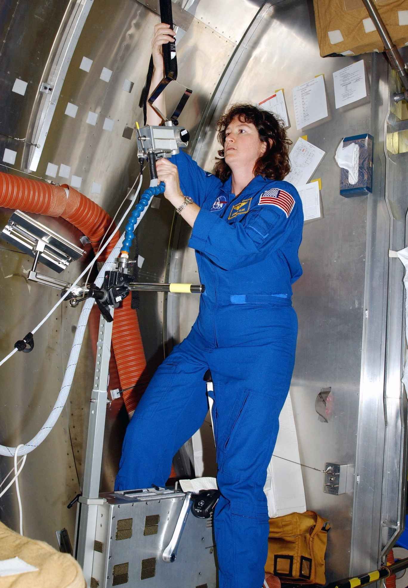 STS-107 Mission Specialist Laurel Clark gets acquainted with mission equipment at SPACEHAB at Cape Canaveral, Florida. The investigations spanned the biological sciences (with plenty of rats) and the material sciences. One of the tests was a modular, extensible Hitchhiker carrier system that could be used to carry heavier payloads.