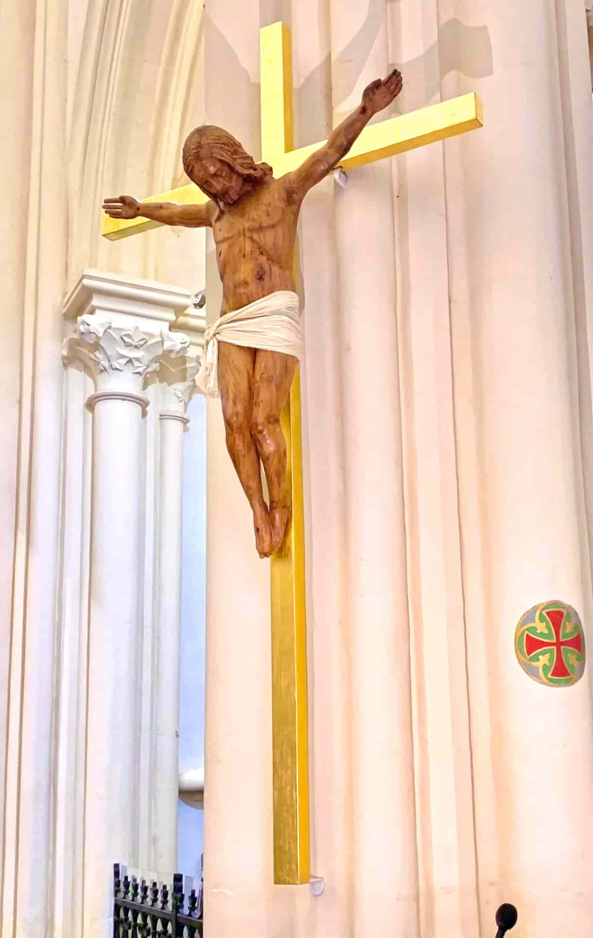 A big cross in gilded wood with Jesus Christ crucified in a perizoma.