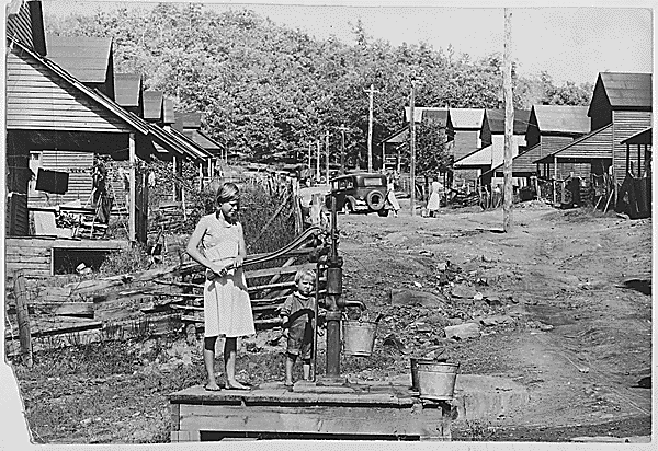 Pumping water by hand from the sole water supply in this section of Wilder, Tennessee (Tennessee Valley Authority, 1942)