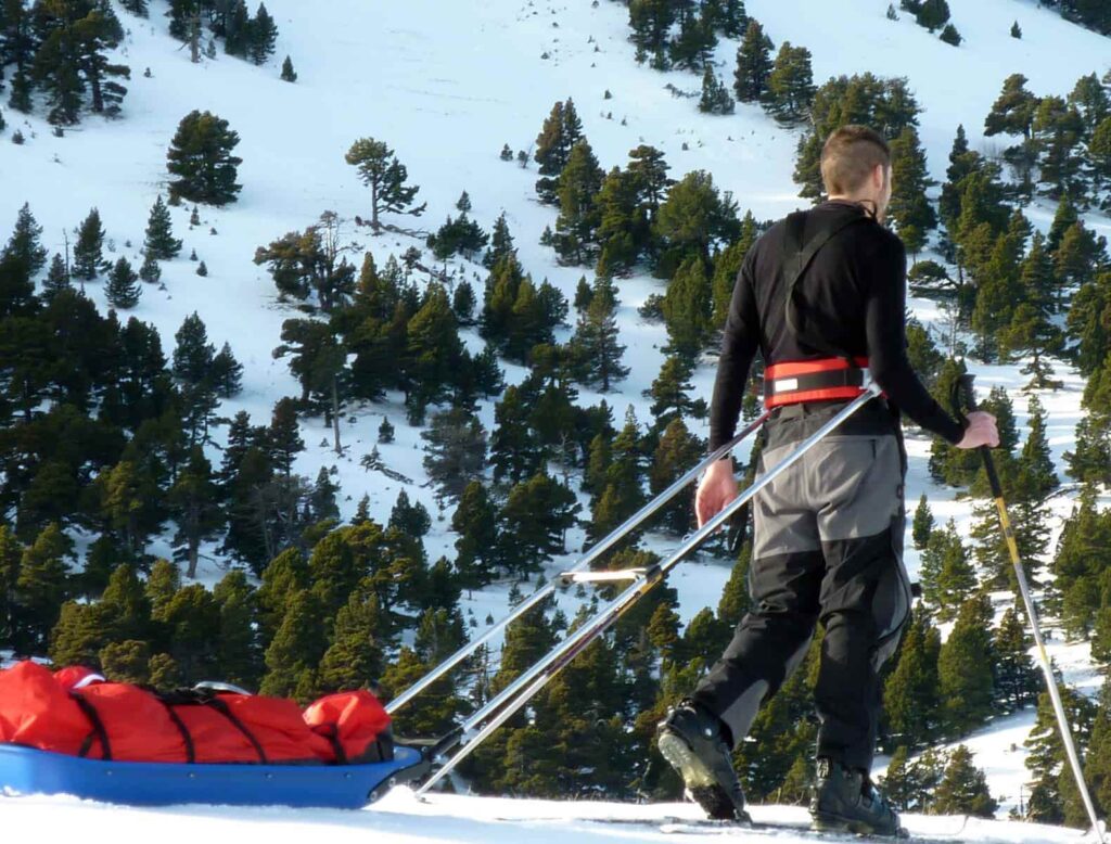 Nordic ski tourer towing a plastic pulk in the Vercors Massif, France.