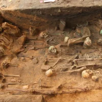 Dead buried in a sitting position (left) and people lying on their side (bottom half) with a dense filling in the center of the pit