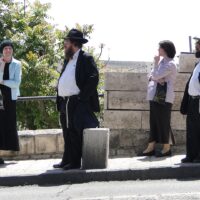 Two Haredi Jewish couples at a bus stop in Jerusalem