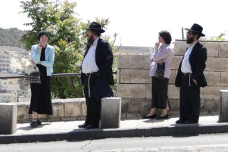 Two Haredi Jewish couples at a bus stop in Jerusalem