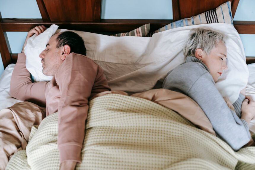 Diverse spouses sleeping on bed under plaid