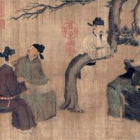 Four men dressed in robes and black square cut hats gather around a tree talking to one another. Three are sitting on rocks while the fourth is leaning over a horizontally bent branch of the tree